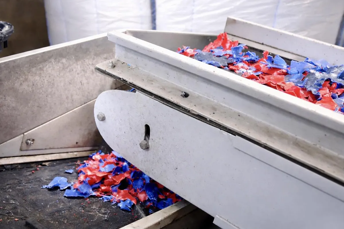 Shredded red and blue plastic on processing equipment