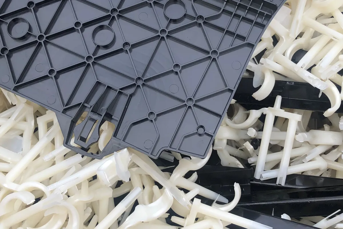 A grey moulded plastic panel resting on white plastic offcuts